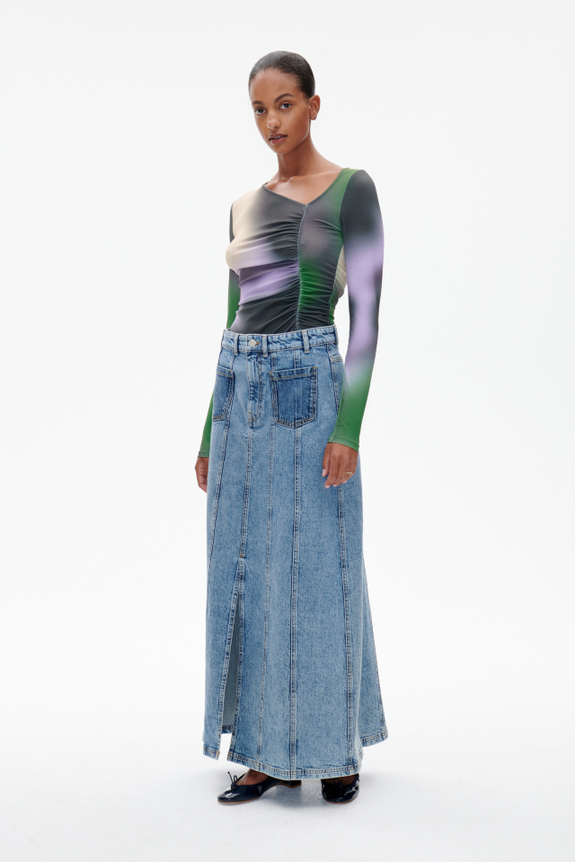 Susanna Skirt Medio Blue Denim This A-line, maxi denim skirt features a zip fly with button closure, as well as patch pockets in the front and back - model image
