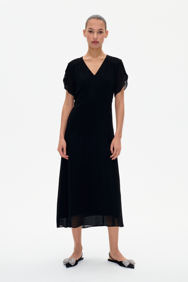 Aiyanna Vestido Black Este vestido midi presenta cuello de pico, cierre de cremallera en el lateral y mangas sueltas - model image