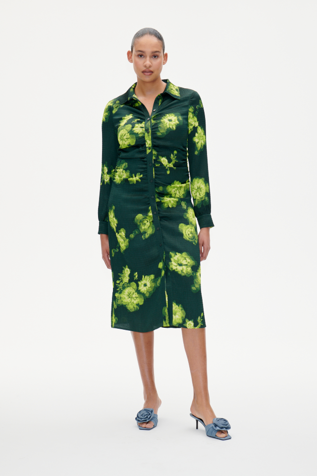 Abira Dress Green Margot Flower This midi-length shirt dress features button closures in the front, buttoned cuffs, and ruching at the sides for a flattering drape - model image