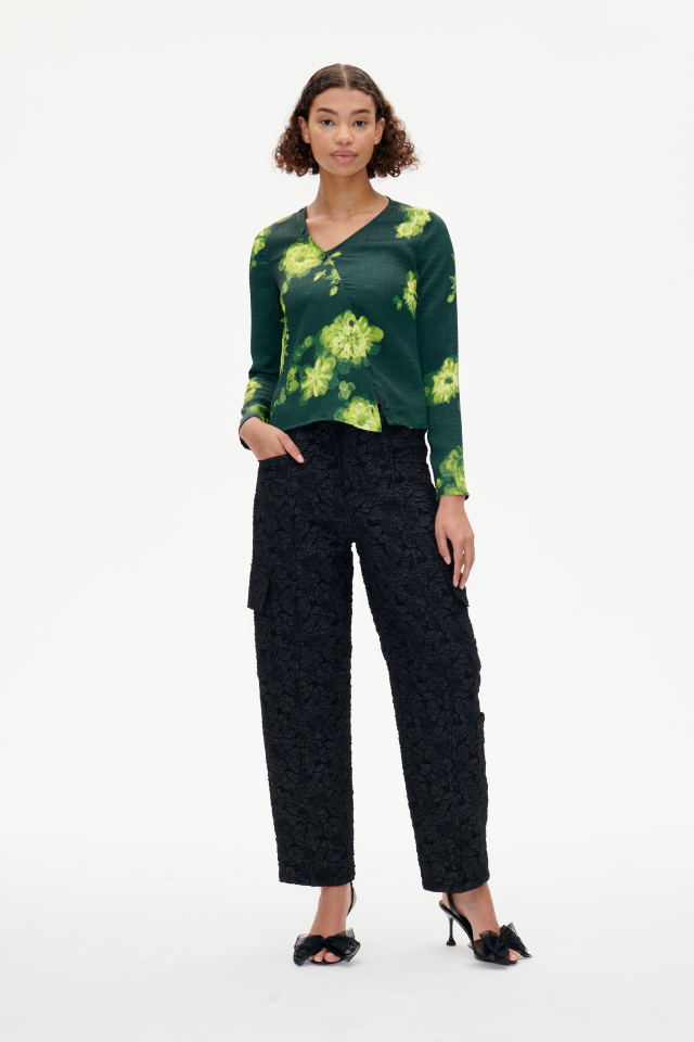 Maia Blouse Green Margot Flower This soft top features an asymmetrical neckline and button closures with extra buttons running up the neck - model image