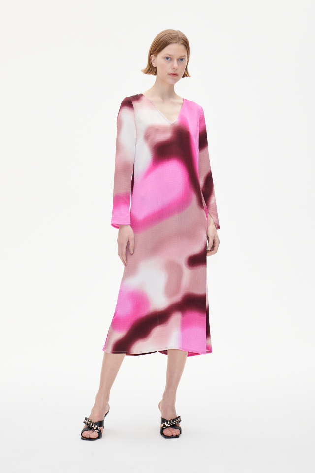 Amilo Dress Pink Fade This midi-length column dress features a V-neck, zip closure in the back, and slits at the ends of the sleeves - model image