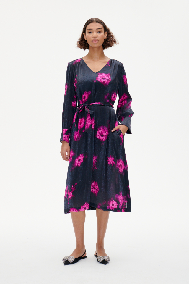Aradina Dress Pink Margot Flower This midi-length, V-neck dress features a removable tie belt at the waist, oversized cuffs, pockets, and slits at the sides - model image