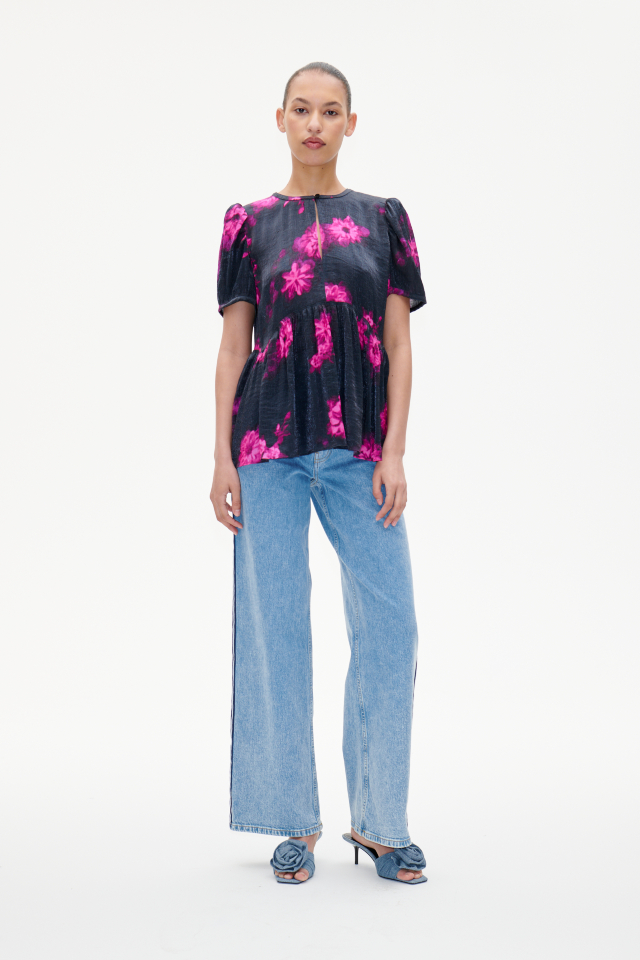 Mava Blouse Pink Margot Flower This short sleeve top features a button closure with keyhole opening at the back and a peplum-style hem for a flared look - model image