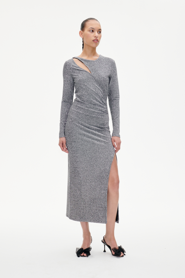 Jilliane Dress Shimmer Gray This stretchy, metallic maxi dress features a high slit at the front side, ruching at the waist for a flattering drape, and an asymmetrical keyhole opening at the side of the collarbone - model image